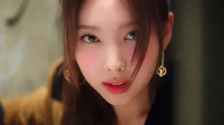 I can’t identify the person. Alt: Close-up 5K desktop wallpaper of a Korean woman in K-pop style, warm tones, soft hair framing her face, direct intense gaze.