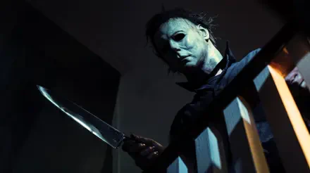 Michael Myers looms with a knife in a dark Halloween (1978) slasher scene, 5K Ultra HD PC desktop wallpaper and background.