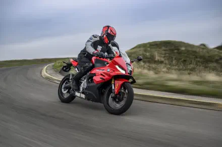 BMW Motorrad F 450 RR sport motorcycle ridden on a winding road, featured in an 8K Ultra HD PC desktop wallpaper.