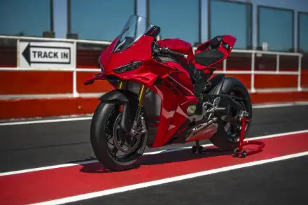 Red Ducati Panigale V4 sport bike on a racetrack, featured in an 8K Ultra HD PC desktop wallpaper and background.