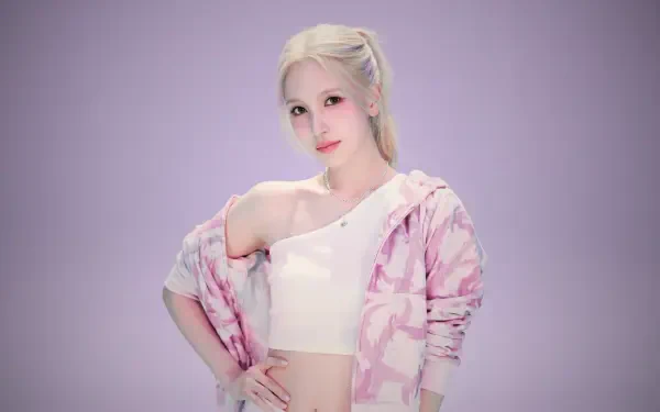 5K desktop wallpaper of a blonde K-pop–style singer/model in a white crop top and pastel pink jacket, posing confidently against a soft lavender background.