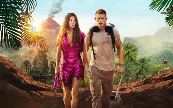 The Lost City (2022) 4K Ultra HD PC desktop wallpaper: woman in a fuchsia dress and man with a backpack and shovel trekking a jungle path toward an erupting volcano, palm fronds framing them.