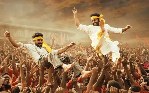 RRR 4K Ultra HD PC Desktop Wallpaper: two jubilant men in yellow scarves leaping above a roaring crowd under dramatic sunset skies, hands raised in celebration.