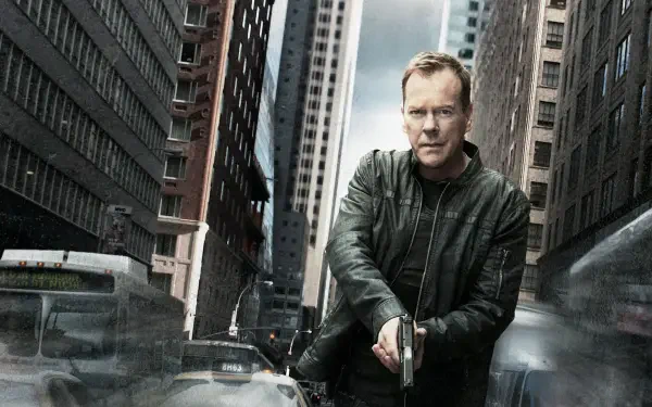 Brooding man in a leather jacket aiming a handgun between towering city buildings with motion-blurred cars — 24-tagged 4K Ultra HD PC desktop wallpaper and background.