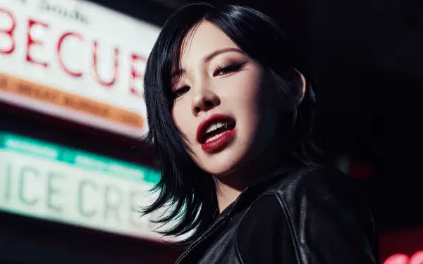 5K Ultra HD desktop wallpaper: close-up of a vampiric, K-pop–styled woman with dark hair, red lips and leather jacket, lit by neon signs.