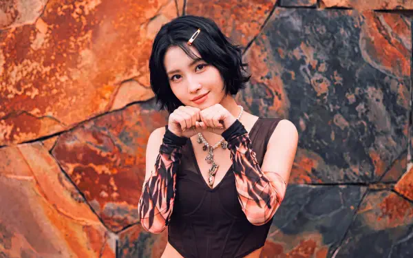 5K Ultra HD desktop wallpaper: short-haired Japanese model posing with hands near her face against a rusted stone backdrop, styled in a K-pop idol TWICE/MiSaMo aesthetic.