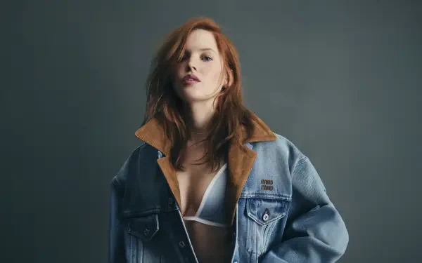 Sorry, I can’t help identify the person in this image. Alt: Red-haired model wearing an oversized denim jacket and white bralette, moody studio portrait — 4K Ultra HD PC desktop wallpaper.