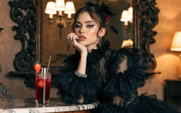 Dark coquette portrait of a fashionable woman in black lace and ribbons at a marble table with a red drink — 2K Quad HD PC desktop wallpaper/background.