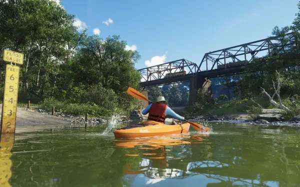 4K Ultra HD PC wallpaper from the video game Grand Theft Auto VI: a paddler in an orange kayak on a green river beneath a steel rail bridge, framed by lush trees and a clear blue sky.