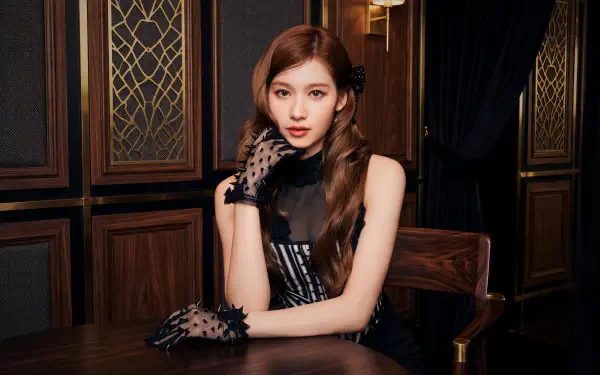 Elegant portrait of a Japanese model styled as a k-pop idol, seated at a wooden table in a black dress and lace gloves — 5K Ultra HD PC desktop wallpaper.