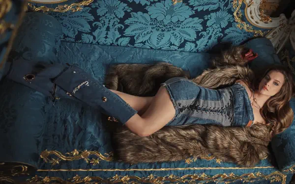 4K Ultra HD PC wallpaper: woman reclining on an ornate teal damask sofa, wearing a denim outfit and fur coat, posed in an elegant boudoir setting.