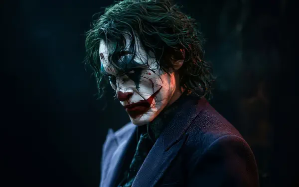 4K Ultra HD PC desktop wallpaper: brooding Joker portrait with smeared clown makeup, red-lipped grin and dark suit set against a shadowy, cinematic backdrop.