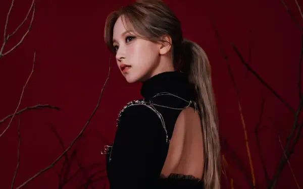 5K desktop wallpaper: side profile of a Japanese model and singer in K-pop–inspired styling, black open-back outfit and ponytail against a deep red background.