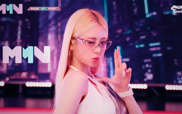 Blonde K-pop idol in glasses striking a finger-gun pose against a neon, Overwatch 2–style cityscape; vibrant pink and cyan lighting, 5K Ultra HD PC desktop wallpaper.