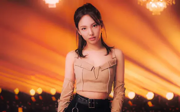 5K Ultra HD desktop wallpaper of a Korean K-pop idol model: young woman in a beige cropped top and black pants, standing center stage with warm golden spotlights radiating behind her.