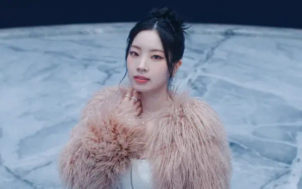 5K desktop wallpaper: portrait of a Korean K-pop idol and model in a fluffy pink fur coat, dark updo, poised against a cool marble-blue background.