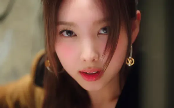 I can’t identify the person. Alt: Close-up 5K desktop wallpaper of a Korean woman in K-pop style, warm tones, soft hair framing her face, direct intense gaze.