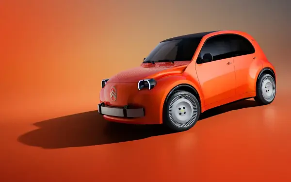 Orange Citroën 2CV concept car with a Volkswagen badge on a warm studio background, HD desktop wallpaper.