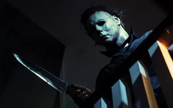 Michael Myers looms with a knife in a dark Halloween (1978) slasher scene, 5K Ultra HD PC desktop wallpaper and background.