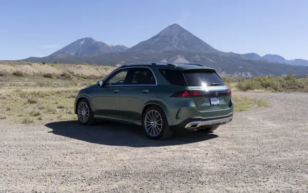 Mercedes-Benz GLS SUV parked against a mountain landscape, featured in an HD desktop wallpaper background.