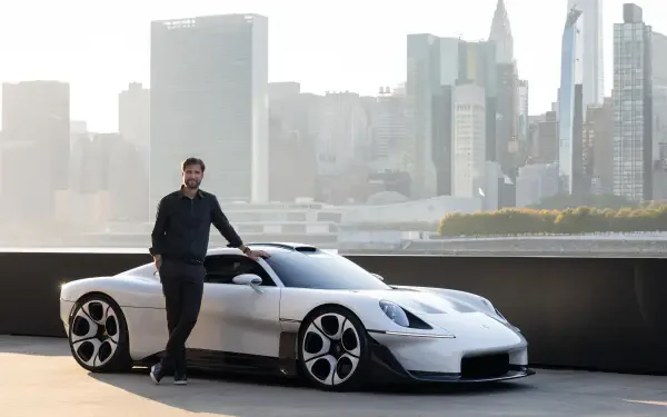 White Porsche Mission S electric sports car and man against a city skyline, 5K Ultra HD desktop wallpaper.