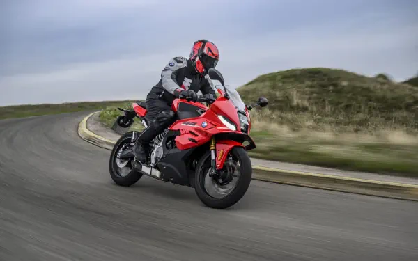 BMW Motorrad F 450 RR sport motorcycle ridden on a winding road, featured in an 8K Ultra HD PC desktop wallpaper.