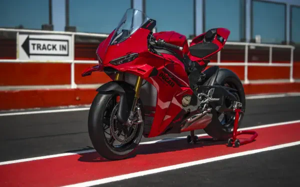 Red Ducati Panigale V4 sport bike on a racetrack, featured in an 8K Ultra HD PC desktop wallpaper and background.