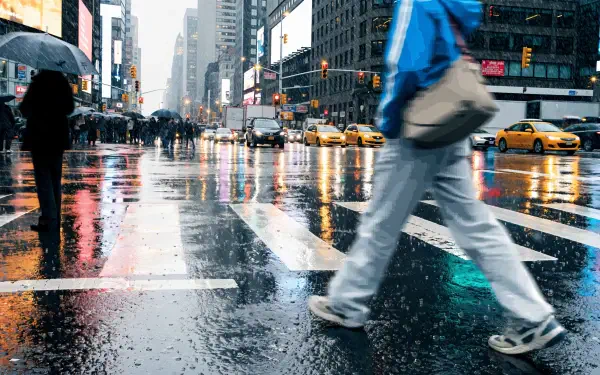 Rainy city street photography of a pedestrian crossing reflective pavement among taxis, 4K Ultra HD PC desktop wallpaper and background.