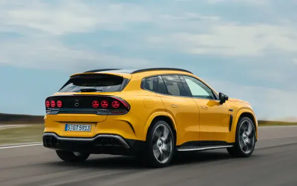 Yellow Mercedes-AMG GT SUV driving on a road, 2K Quad HD PC desktop wallpaper background.
