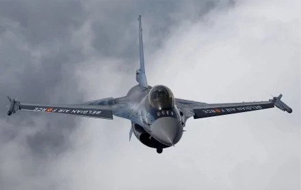 4K Ultra HD image of a General Dynamics F-16 Fighting Falcon military airplane flying through cloudy skies as a PC desktop wallpaper background.