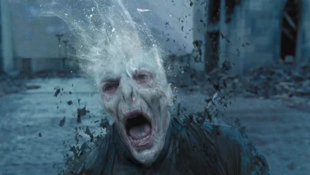 HD PC desktop wallpaper: Lord Voldemort from Harry Potter and the Deathly Hallows: Part 2, screaming as his face and body dissolve amid flying debris on a ruined battlefield.