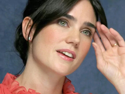 HD desktop wallpaper featuring Jennifer Connelly, showcasing her expressive gaze and elegant style against a soft blue background.