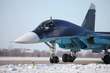 A military Sukhoi Su-34 fighter jet taxiing on a snowy runway, captured in high-resolution 4K Ultra HD for PC desktop background.