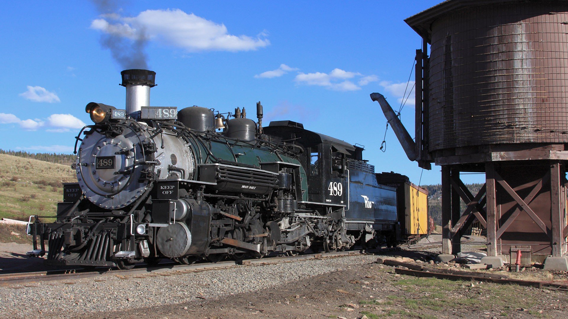 A historic steam train, numbered 456, steams beside a wooden water tower under a blue sky, showcasing the beauty of vintage vehicles in a scenic landscape. Desktop wallpaper and background.