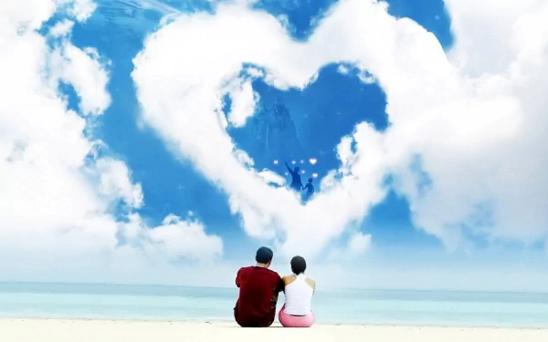 An HD desktop wallpaper showing an artistic scene of a couple sitting on a beach, looking at a large heart-shaped cloud in the sky, evoking feelings of love and serenity.