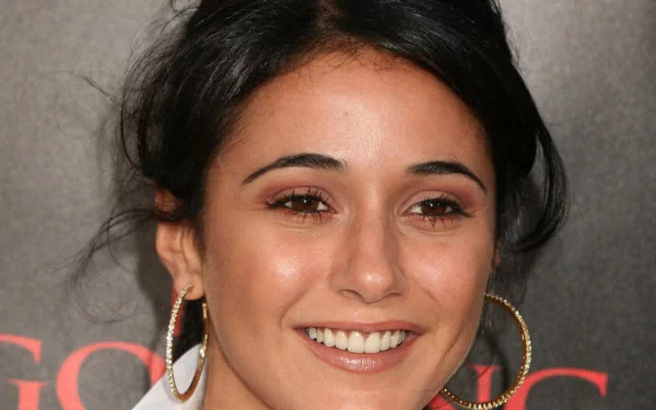 2K Quad HD PC desktop wallpaper showing a close-up of a smiling woman with dark hair, hoop earrings and warm makeup against a dark backdrop.