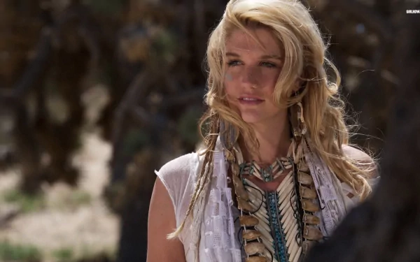 HD PC desktop wallpaper showing a music artist outdoors — sunlit, wind‑blown hair, layered necklaces and bohemian clothing, gazing off camera.