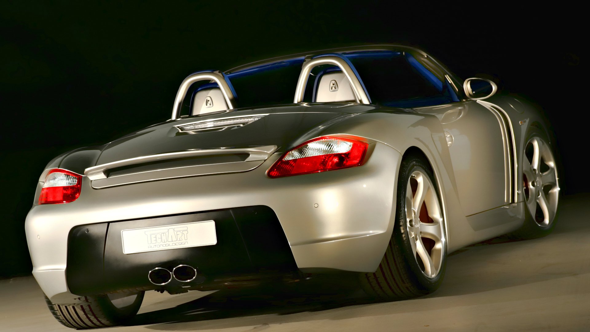 Silver Porsche convertible sports car, rear three-quarter view with studio lighting and glossy finish — HD PC desktop wallpaper.