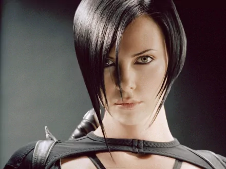 Charlize Theron in a striking pose from the movie *Aeon Flux*, featuring a sleek look that highlights her intense gaze and dynamic character. HD desktop wallpaper.