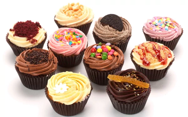 A vibrant assortment of decorated cupcakes with various frostings and toppings, captured in stunning 4K Ultra HD for a PC desktop wallpaper background.