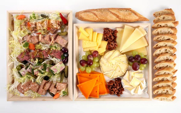 4K Ultra HD PC desktop wallpaper of a food spread: a cheese board with assorted cheeses, grapes and nuts, sliced baguette and a mixed salad with sliced meat.