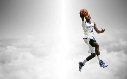 HD desktop wallpaper featuring a Kentucky Wildcats basketball player soaring for a slam dunk against a bright, cloudy background.