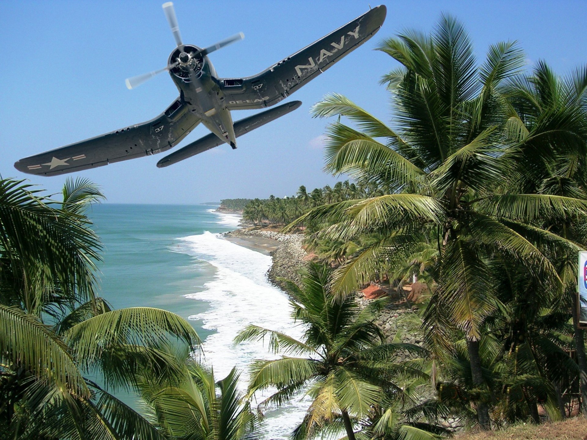 HD desktop wallpaper featuring a military Vought F4U Corsair flying low over a tropical coastline with palm trees and ocean waves below.