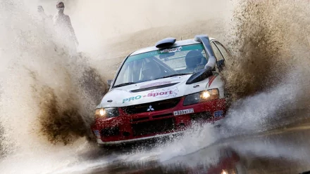 HD PC desktop wallpaper and background of a Mitsubishi rally vehicle charging through water, mud spraying around the speeding car.
