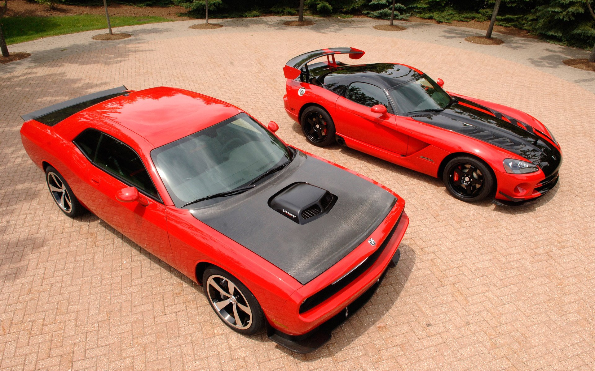 HD PC desktop wallpaper and background showing two red Dodge vehicles parked on a sunlit brick plaza with black hoods and sporty styling, overhead view.