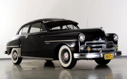 HD desktop wallpaper of a sleek black 1950 Dodge Wayfarer Coupe showcased in a glossy studio setting.