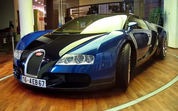 A striking Bugatti vehicle displayed indoors, showcasing its sleek design and vibrant blue and black exterior. This HD image serves as an impressive desktop wallpaper.