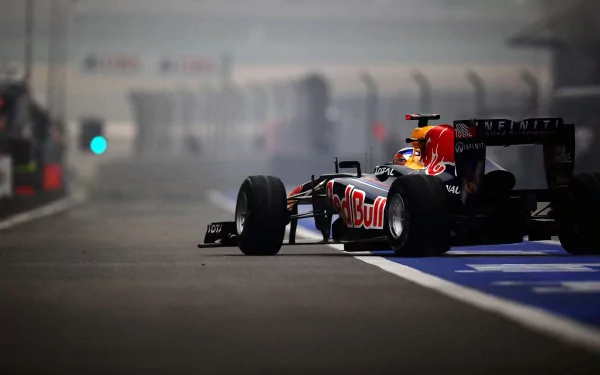 A dynamic F1 racing car from Red Bull, captured in a misty pit lane, makes for an engaging HD desktop wallpaper, celebrating the thrill of sports and speed.