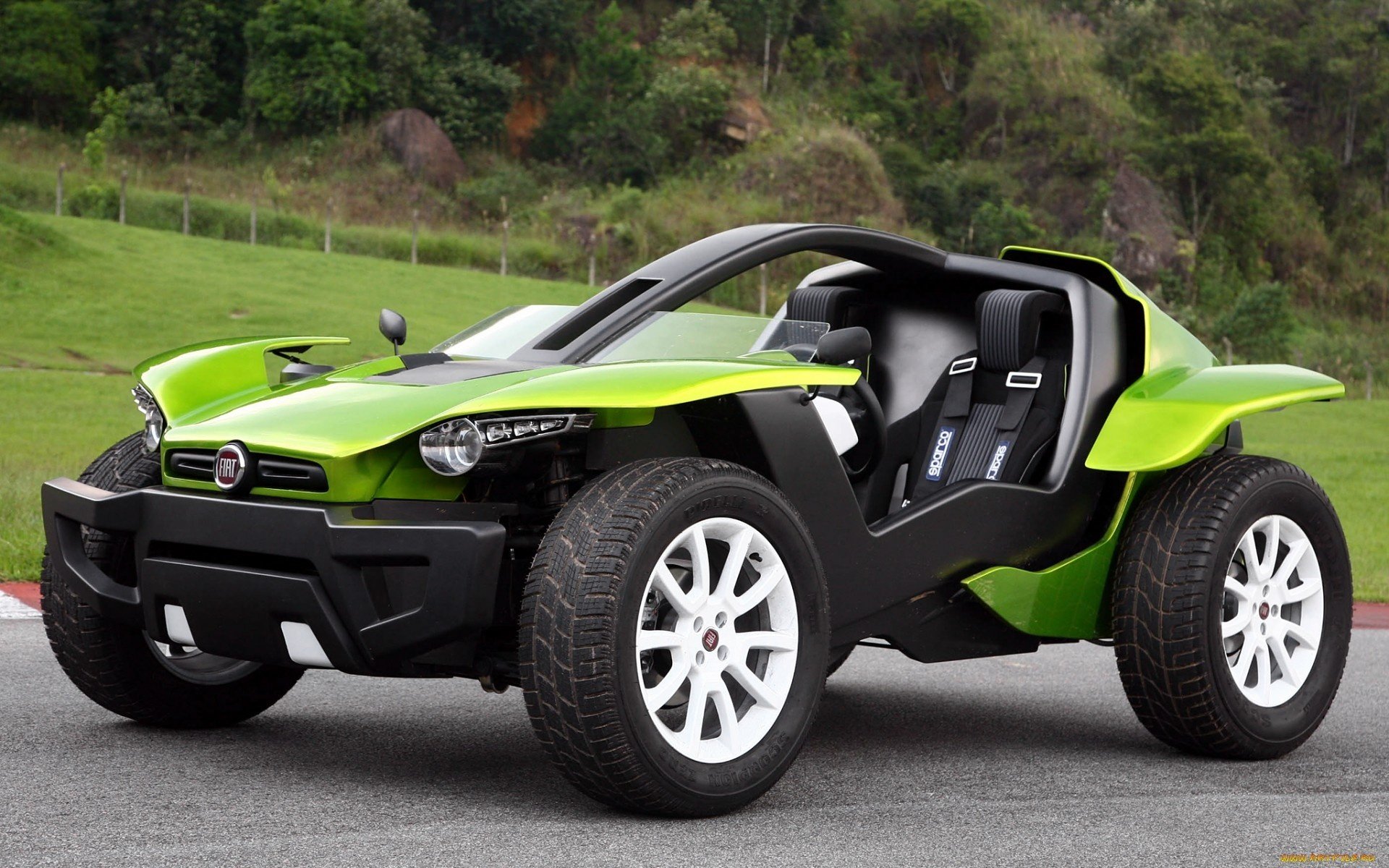 HD PC desktop wallpaper/background of a bright green Fiat open-top concept vehicle with large off-road tires parked on pavement in front of a grassy hillside.