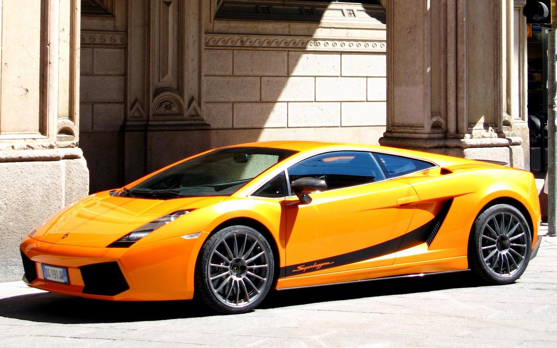 Orange Lamborghini Gallardo Superleggera in a sunlit urban courtyard, crisp HD PC desktop wallpaper and background.